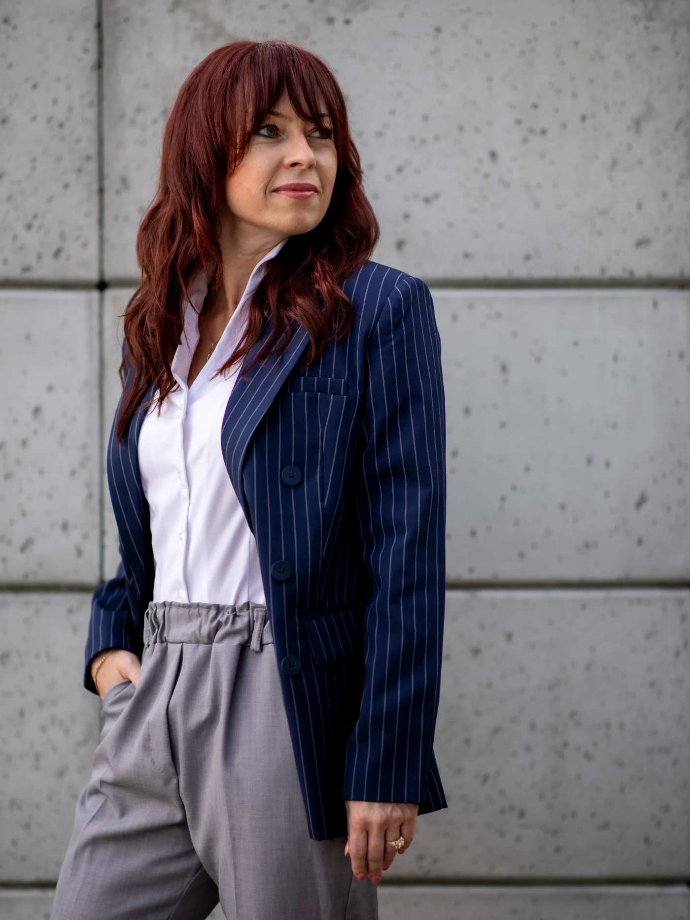 Anna Sarbiewska w granatowej marynarce na tle architektury